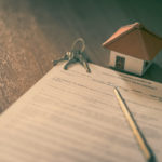 House keys on the rental agreement or the buy home contracts with the real estate property background. House keys on the rental agreement or the buy home contracts with the real estate property background.